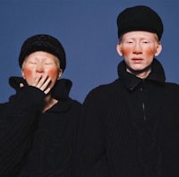 two people wearing black sweaters and hats