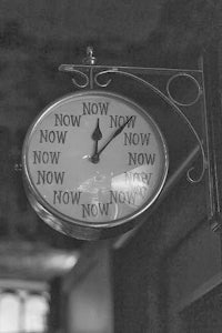 a black and white photo of a clock hanging on a wall