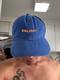 a man wearing a blue hat with the word holiday on it